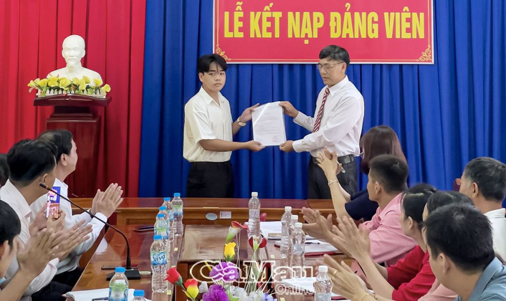 Thầy Lê Thanh Giang, Bí thư Chi bộ, Hiệu trưởng Trường THCS&THPT Khánh An, trao quyết định kết nạp đảng viên cho em Nguyễn Trọng Nhân.